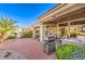 Covered outdoor patio with built in barbeque and seating area with manicured landscaping at 10700 Back Plains Dr, Las Vegas, NV 89134