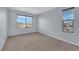 Bedroom with neutral walls and carpet, and a view of neighborhood homes through large window at 108 Fiery Hill Ave, Henderson, NV 89011