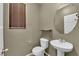 Small powder room with round mirror, pedestal sink and modern fixtures at 108 Fiery Hill Ave, Henderson, NV 89011