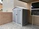 Backyard featuring a gray shed with double doors on a stone tile surface, offering practical outdoor storage at 108 Fiery Hill Ave, Henderson, NV 89011