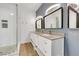 Modern bathroom with double sinks, granite countertops, a glass-enclosed shower, and wood-style flooring at 108 Lemon Glaze St # 202, Las Vegas, NV 89145