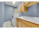 A laundry room with wooden cabinets and a stacked washer and dryer at 108 Lemon Glaze St # 202, Las Vegas, NV 89145