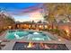 Amazing backyard featuring a pool, spa, outdoor kitchen, covered patio, and black rock fire pit at 11099 Moonlight Fire Ct, Las Vegas, NV 89135