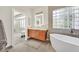 Bright main bathroom featuring a soaking tub, custom vanities, and tile flooring at 11099 Moonlight Fire Ct, Las Vegas, NV 89135