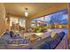 Relaxing covered patio with comfortable seating, an outdoor TV area, and view of the pool and landscaped backyard at 11099 Moonlight Fire Ct, Las Vegas, NV 89135