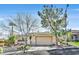 Charming home featuring a brick driveway, two-car garage, desert landscaping, and beautiful mature trees at 11099 Moonlight Fire Ct, Las Vegas, NV 89135