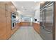 Bright, modern kitchen with wood cabinetry, stainless steel appliances, and a view to the living area at 11099 Moonlight Fire Ct, Las Vegas, NV 89135