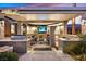Stunning covered outdoor living space featuring a built-in kitchen, BBQ, TV, fireplace and ample seating, perfect for entertaining at 11099 Moonlight Fire Ct, Las Vegas, NV 89135