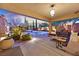 Luxurious outdoor living space with comfortable seating, covered patio, and a scenic pool and landscaped yard view at 11099 Moonlight Fire Ct, Las Vegas, NV 89135
