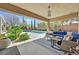 Relaxing covered patio with comfortable seating, overlooking the lush landscaping and refreshing pool area at 11099 Moonlight Fire Ct, Las Vegas, NV 89135