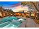 Inviting pool and spa area with an outdoor kitchen, a covered patio, and an outdoor television at 11099 Moonlight Fire Ct, Las Vegas, NV 89135