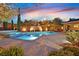 Stunning pool and spa surrounded by lush landscaping, a brick wall, and lounge chairs at 11099 Moonlight Fire Ct, Las Vegas, NV 89135
