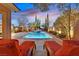 Beautiful pool area with lounge chairs, a hot tub, and elegant landscaping at twilight at 11099 Moonlight Fire Ct, Las Vegas, NV 89135