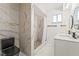 Bathroom with double sinks, marble floors, tiled shower and marbled walls at 1300 Oak Tree Ln, Las Vegas, NV 89108