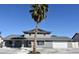 Charming two-story home with a palm tree, gray stucco, gray roof, and well maintained front yard at 1300 Oak Tree Ln, Las Vegas, NV 89108