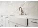 Close-up of a kitchen sink, featuring a farm sink, modern faucet, and marble countertops at 1300 Oak Tree Ln, Las Vegas, NV 89108