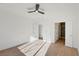 Bright bedroom with hardwood floors, white walls, a ceiling fan, and two entry points at 2511 Jada Dr, Henderson, NV 89044