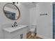 Modern bathroom features a round mirror, white vanity and blue tiled shower at 2605 Amarillo St, Las Vegas, NV 89102