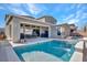 Exterior view of a private backyard featuring a pool, spa, and covered patio with outdoor seating at 3004 Barrett Springs Ave, Henderson, NV 89044