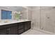 Modern bathroom featuring double sinks, a large mirror, and a glass-enclosed shower with tiled walls at 3004 Barrett Springs Ave, Henderson, NV 89044