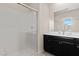 Bright bathroom featuring a glass enclosed shower and dark cabinetry at 3004 Barrett Springs Ave, Henderson, NV 89044