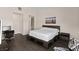 Spacious bedroom with dark wood floors, a modern platform bed, and a serene beach scene wall art at 3004 Barrett Springs Ave, Henderson, NV 89044