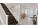 Inviting entryway with dark wood staircase and neutral tile floors leading to a bright and airy living space at 3004 Barrett Springs Ave, Henderson, NV 89044