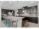Kitchen featuring a large island with seating, dark cabinetry, and stainless steel appliances at 3004 Barrett Springs Ave, Henderson, NV 89044