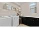 Laundry room with washer, dryer, storage cabinets, and a window for natural light at 3004 Barrett Springs Ave, Henderson, NV 89044