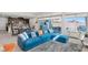 Living room with a blue sectional, a gray rug, and a view of the open-plan kitchen and dining area at 3004 Barrett Springs Ave, Henderson, NV 89044