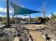 Outdoor playground with swings and shade canopies, surrounded by natural desert landscaping at 3004 Barrett Springs Ave, Henderson, NV 89044