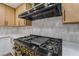 Kitchen with stainless steel gas range, a modern exhaust hood, and updated cabinets with luxury hardware at 3467 W Mardon Ave, Las Vegas, NV 89139