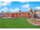 Lush backyard featuring a manicured lawn, mature tree, and covered patio, ideal for outdoor enjoyment at 3920 Geist Ave, Las Vegas, NV 89115