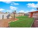 Large backyard offers green grass and gravel landscaping; perfect for outdoor entertaining or relaxation with a covered area at 3920 Geist Ave, Las Vegas, NV 89115