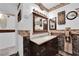 Bathroom featuring decorative fixtures, dark brown wood vanity and framed mirror at 3920 Geist Ave, Las Vegas, NV 89115