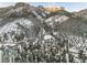 Picturesque aerial view showcasing a mountain community with snow-covered mountains, trees, and homes at 4587 Yellow Pine Ave, Mount Charleston, NV 89124