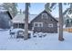 Brown cabin with snow, features a covered patio and cozy charm, nestled amongst tall, snow-laden trees at 4587 Yellow Pine Ave, Mount Charleston, NV 89124