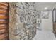Rustic stone fireplace with wooden accents, next to a doorway revealing a tiled floor and a glimpse of artwork at 4587 Yellow Pine Ave, Mount Charleston, NV 89124