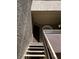 Stairway leading to the entrance door, featuring a unique octagonal window and textured walls in a neutral tone at 5024 S Rainbow Blvd # 203, Las Vegas, NV 89118