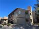 Exterior view of the building showcasing a stucco facade, terracotta tiled roof, and assigned unit numbers above the windows at 5024 S Rainbow Blvd # 203, Las Vegas, NV 89118