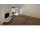 Spacious carpeted living room with a fireplace, sliding glass doors to a balcony, and neutral-colored walls at 5024 S Rainbow Blvd # 203, Las Vegas, NV 89118