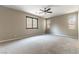 Large bedroom with plush carpet, ceiling fan, and multiple windows for natural light at 5646 Sophie Belle Ave, Las Vegas, NV 89131