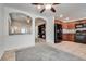 Open living area with neutral walls, tile flooring, arched doorways, and kitchen access at 5928 Radiance Park St, North Las Vegas, NV 89081