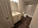 This bathroom features a vanity, toilet and shower, and dark wood-look flooring at 6143 Windmill Island Ave, Las Vegas, NV 89139