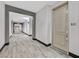 Long hallway with decorative carpeting and gray trim, leading to unit 114 with key lockbox at 62 E Serene Ave # 114, Las Vegas, NV 89123