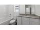 Clean bathroom featuring a shower-tub combo, white vanity with granite countertop, and a bright window at 6252 Blood Lily Ave, Las Vegas, NV 89122