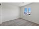 Bright and airy bedroom with carpet, a large window offering ample natural light, and minimalist decor at 6252 Blood Lily Ave, Las Vegas, NV 89122
