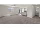 Spacious living room featuring plush carpeting and an open layout, next to the kitchen and bathroom at 6264 Blood Lily Ave, Las Vegas, NV 89122