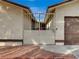 A white wrought iron gate sits between two beige walls of the home's courtyard at 6870 Laronda Ln, Las Vegas, NV 89156
