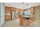 A stylish kitchen with stainless steel appliances, a center island and bar stool seating and lots of wooden cabinets at 6870 Laronda Ln, Las Vegas, NV 89156